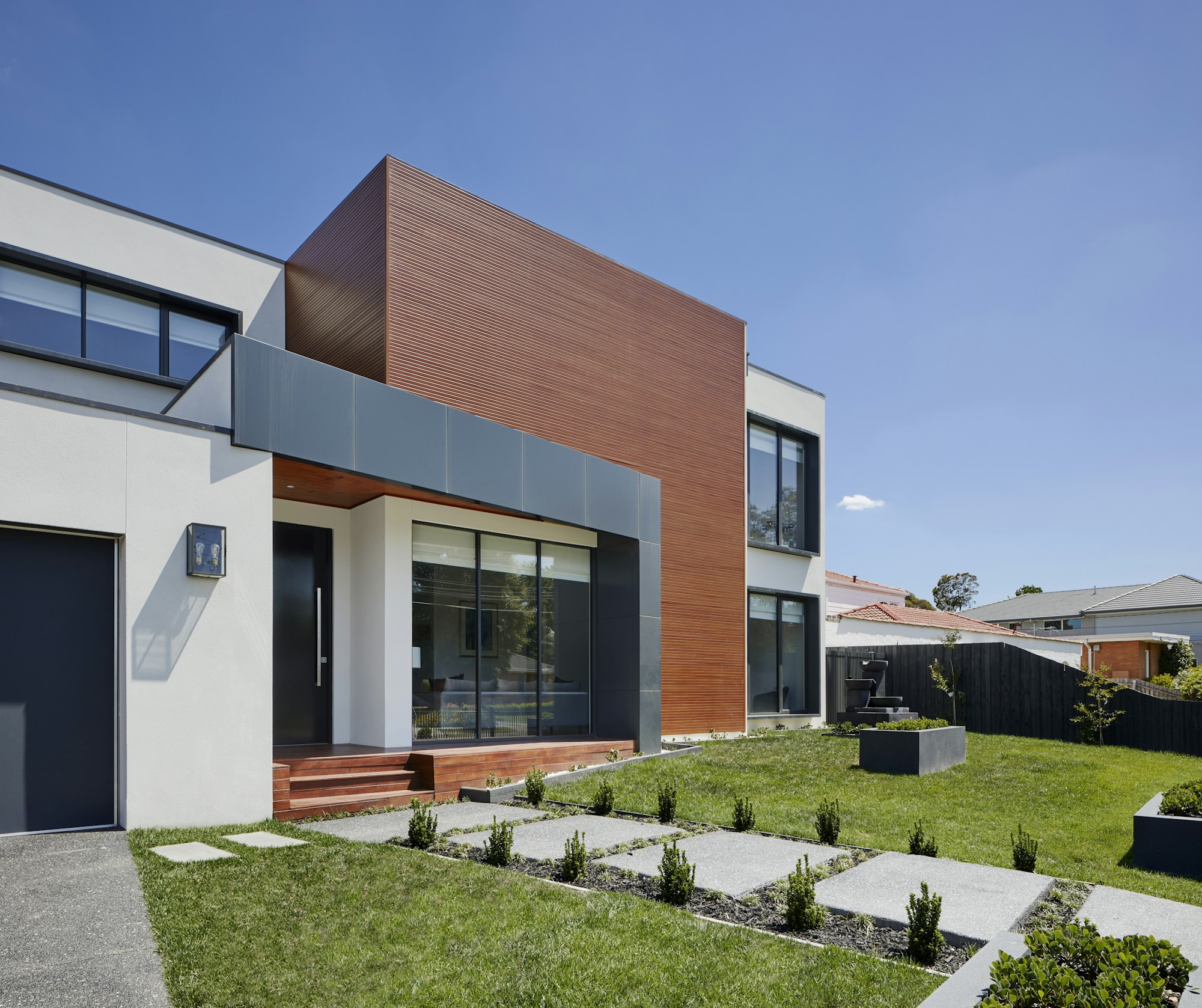 Contemporary house opening onto a sunlit garden