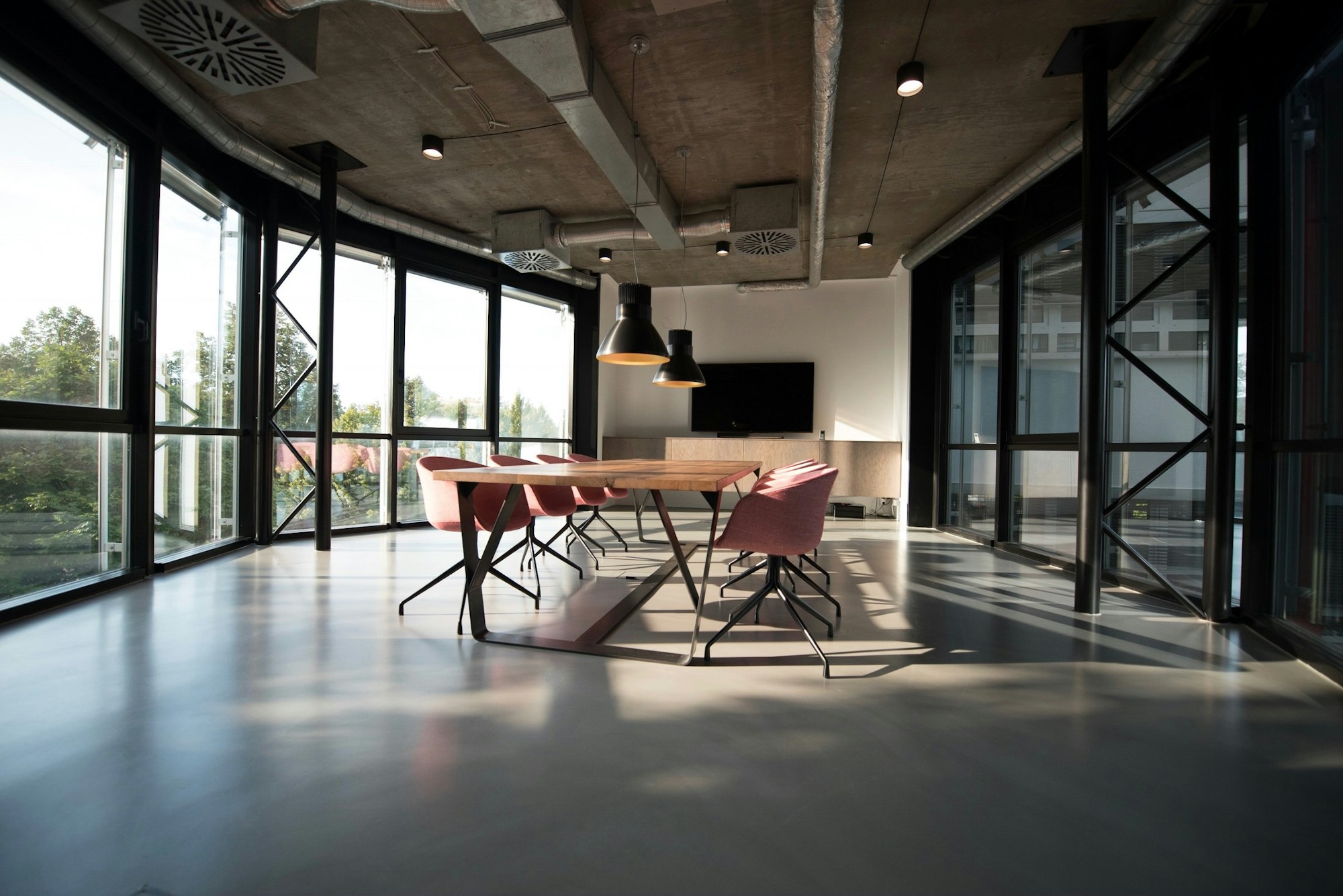 Bright creative workspace with plants, communal tables and large windows